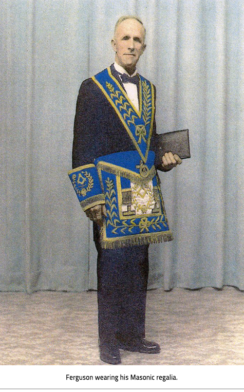 Jerry Ferguson in a suit and bright blue and yellow Masonic regalia. Image Caption: Ferguson wearing his Masonic regalia.
