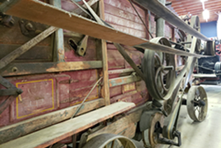 Close up of the side of the Goodison Thresher and it's belts.