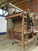 Back end of Goodison Threshing Machine. There is a ladder on the right side of it.