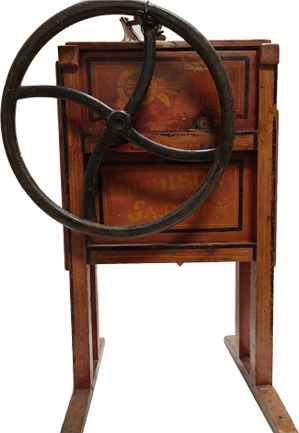 Brown wooden corn sheller. Side with large metal wheel.