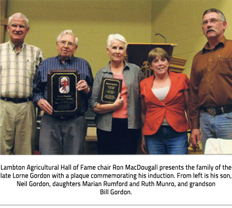   (Image Caption: "Lambton Agricultural Hall of Fame chair Ron MacDougall presents the family of the late Lorne Gordon with a plaque commemorating his induction. From left is his son, Neil Gordon, daughters Marian Rumford and Ruth Munro, and grandson Bill Gordon. "), link.