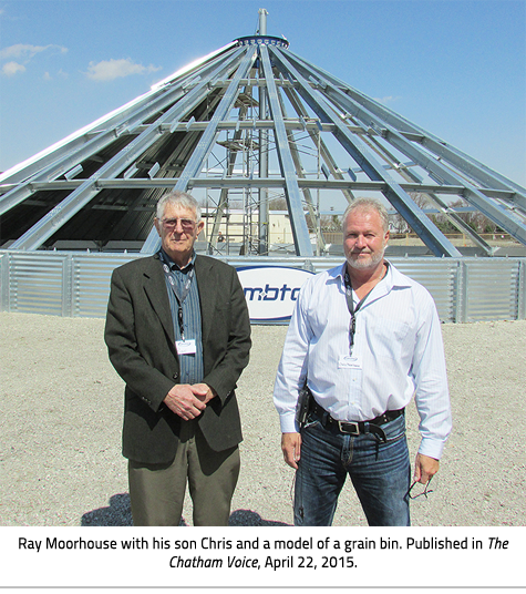 Ray (left) and his son Chris (right) stand in front of a model grain bin. Image Caption:  Ray Moorhouse with his son Chris and a model of a grain bin. Published in The Chatham Voice, April 22, 2015.