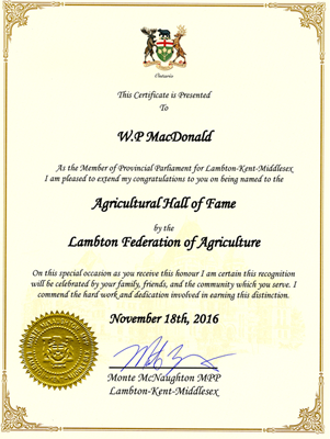 Gold coloured certificate that reads "This certificate is presented to W.P. MacDonald As the Member of Provincial Parliment for Lambton-Kent-Middlesex I am pleased to extend my congratulations to you on being named to the Agricultural Hall of Fame by the Lambton Federation of Agriculture  On this specialoccasion as you receive this honour I am certain this recognition will be celebrated by your family, friends, and the community which you serve. I commend the hard work and dedication involved in earning this distinction. November 18th, 2016  Signed Monte McNaughton MPP Lambton-Kent-Middlesex"