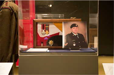 Shadow box with items that symbolize Brent Poland's military service, link.