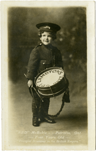 Photo of a child in a military uniform with a drum, link.