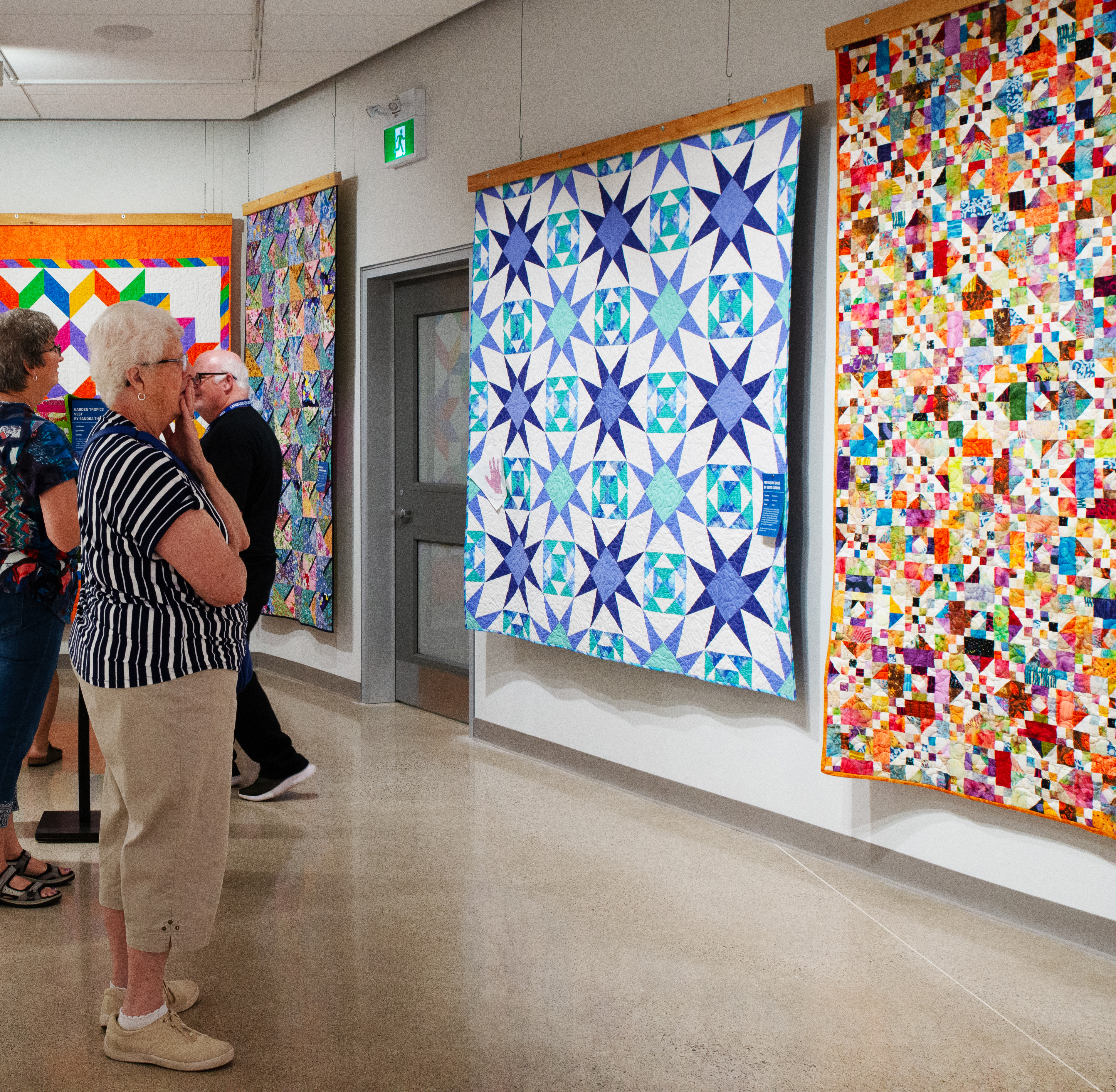 Visitors examine quilts displayed in the 2025 Quilt Show at Lambton Heritage Museum.
