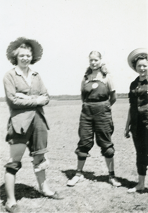 Three farmerettes wearing knee pads.