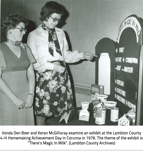 (Image Caption: "Vonda Den Boer and Keran McGillivray examine an exhibit at the Lambton County 4-H Homemaking Achievement Day in Corunna in 1976. The theme of the exhibit is “There's Magic In Milk”. (Lambton County Archives)"), link.