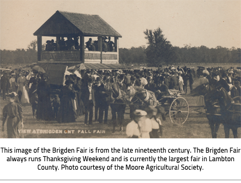 (Sepia toned postcard of a crowd and a pavillion and a crowd at the Brigden Fair. At the bottom, text reads "View at Brigden Ont Fall Fair". Image Caption: "This image of the Brigden Fair is from the late nineteenth century. The Brigden Fair always runs Thanksgiving Weekend and is currently the largest fair in Lambton County. Photo courtesy of the Moore Agricultural Society."), link.