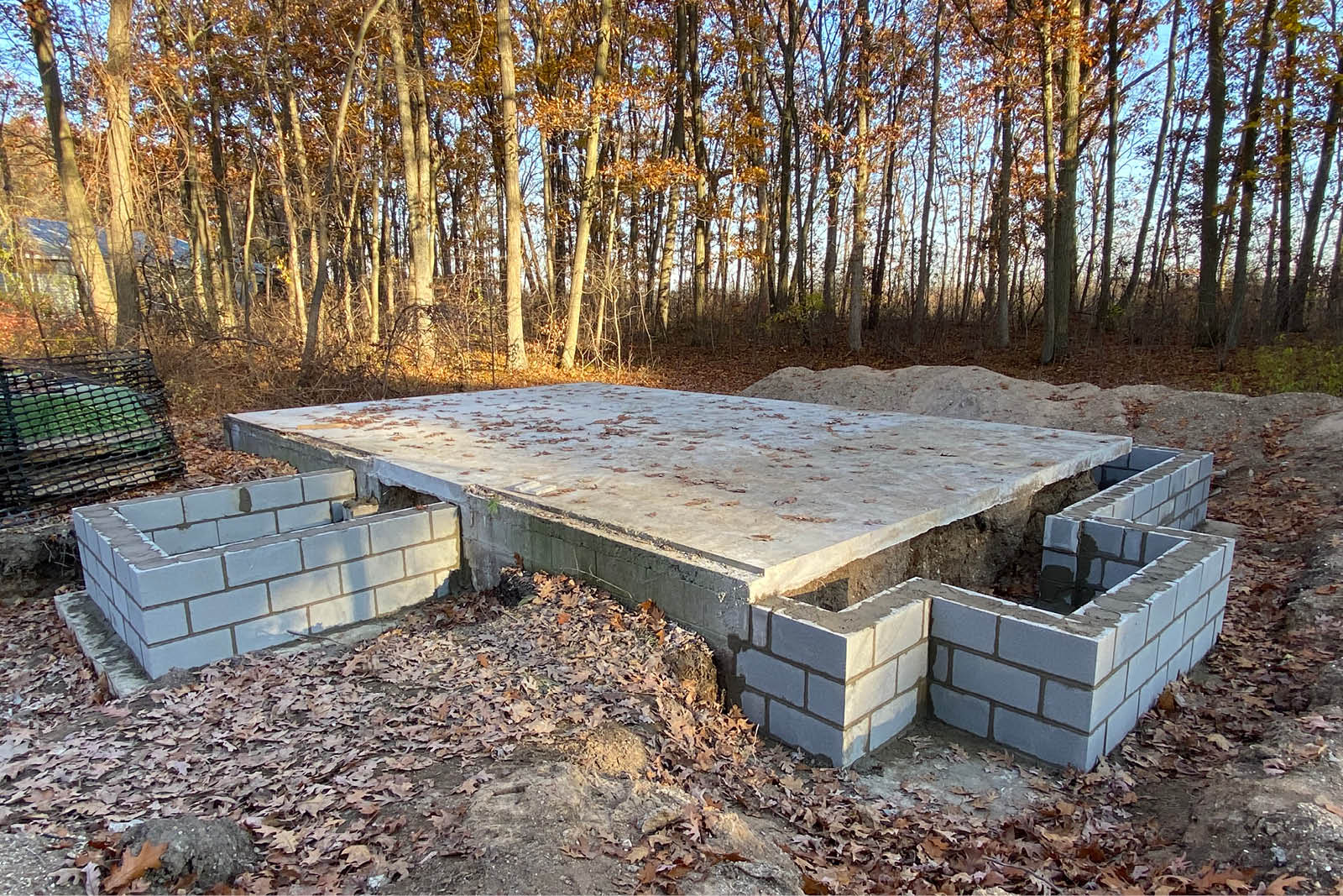 Foundation with blockwork outline of Canatara Cabin footprint amongst autumn forest background.