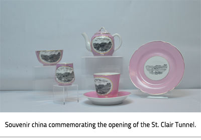 (Pink and white china with imagery commemorating the opening of the St.Clair Tunnel. There is a cup and saucer, a jug, a bowl, a milk , a teapot, and a plate. Image Caption: "Souvenir china commemorating the opening of the St. Clair Tunnel. "), link.