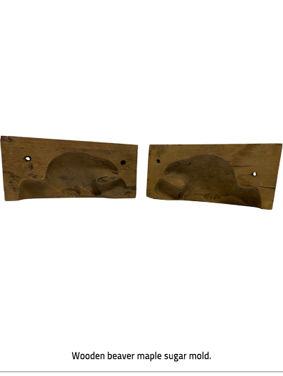 (Two rectangular pieces of wood. The side facing inward is shorter the out side. There is a hole closer to the outside edge of each piece. Image Caption: "Wooden beaver maple sugar mold."), link.