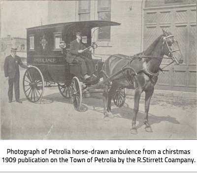 (Black and white image of a field and gravel road with text, " Photograph of the Petrolia horse-drawn ambulance from a Christmas 1909 publication on the Town of Petrolia by the R. Stirrett Company. Image Caption:"Photograph of the Petrolia horse-drawn ambulance from a Christmas 1909 publication on the Town of Petrolia by the R. Stirrett Company."), link.