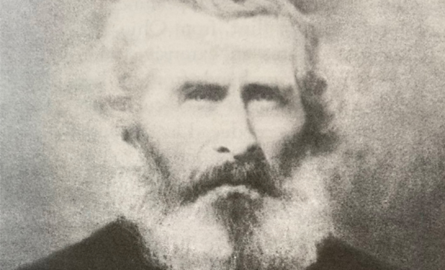 Black and white headshot of a man with a beard.