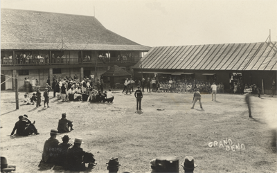 (A group of men play baseball in the 'V' created by the to buildings that make up the casino. People look on from the sidelines and the casino's balcony. In the bottom left corner are the words: "GRAND BEND"), link.