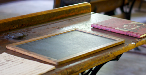 An old school desk with books on it.