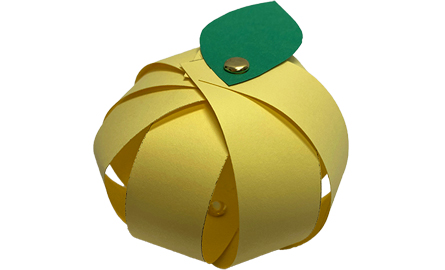 Yellow paper apple with a green paper leaf.
