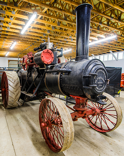 Black tractor in a barn.