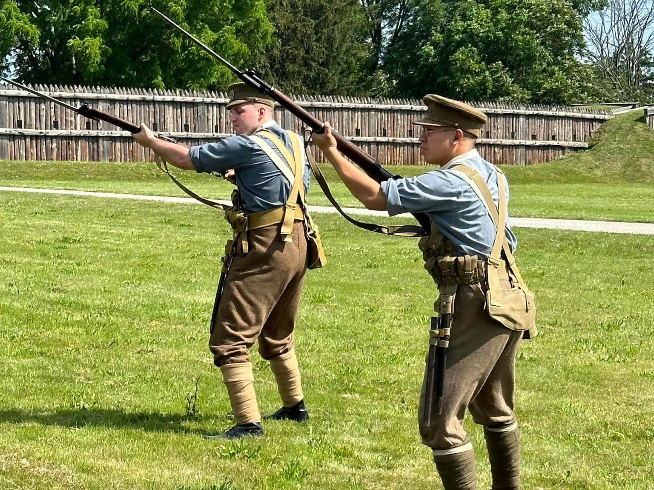 Two members of Dominion of Canada Reenactment Corps hold rifles during an event at Fort George, June 2023.