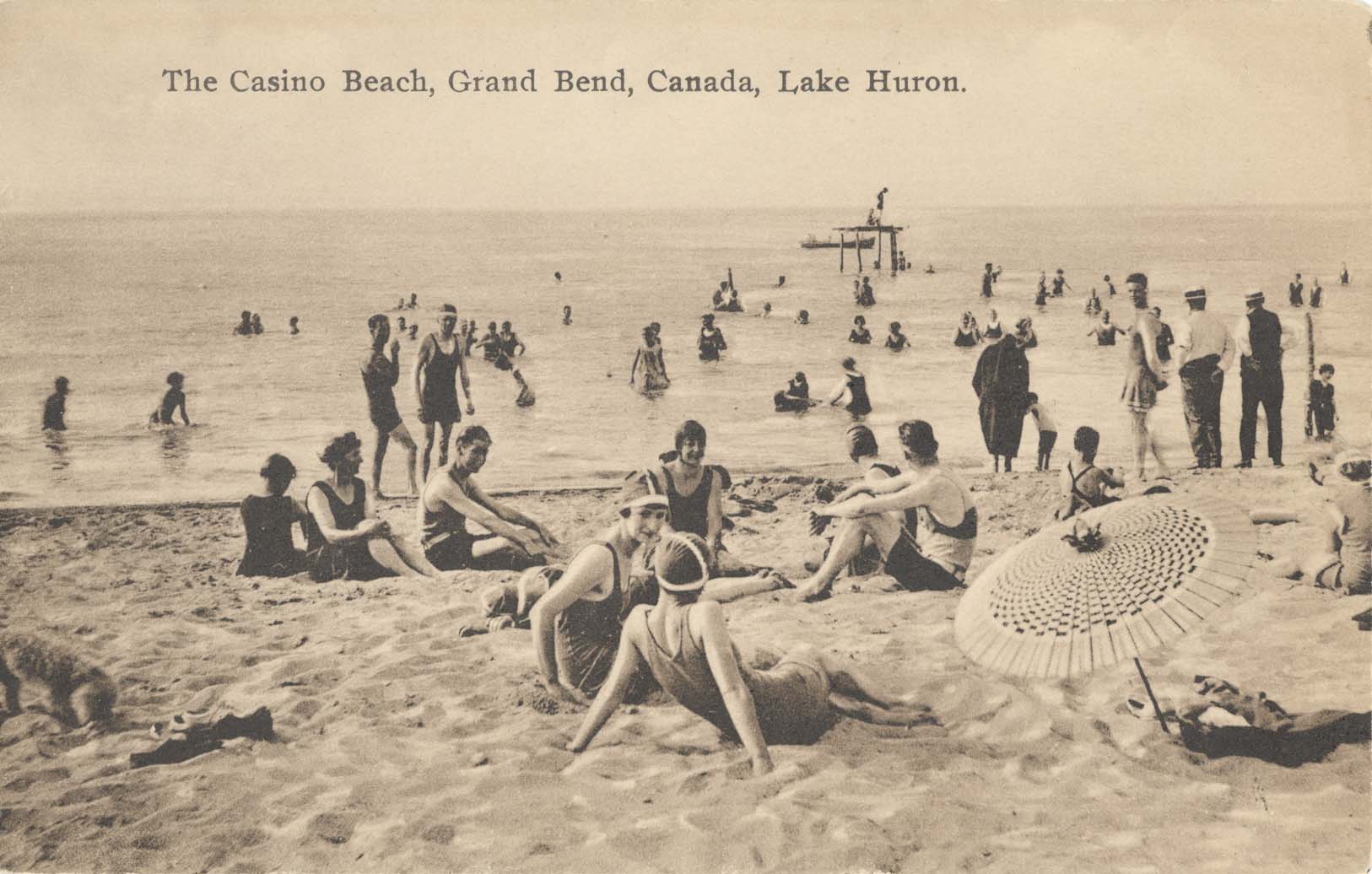 People sitting on the Grand Bend Beach.