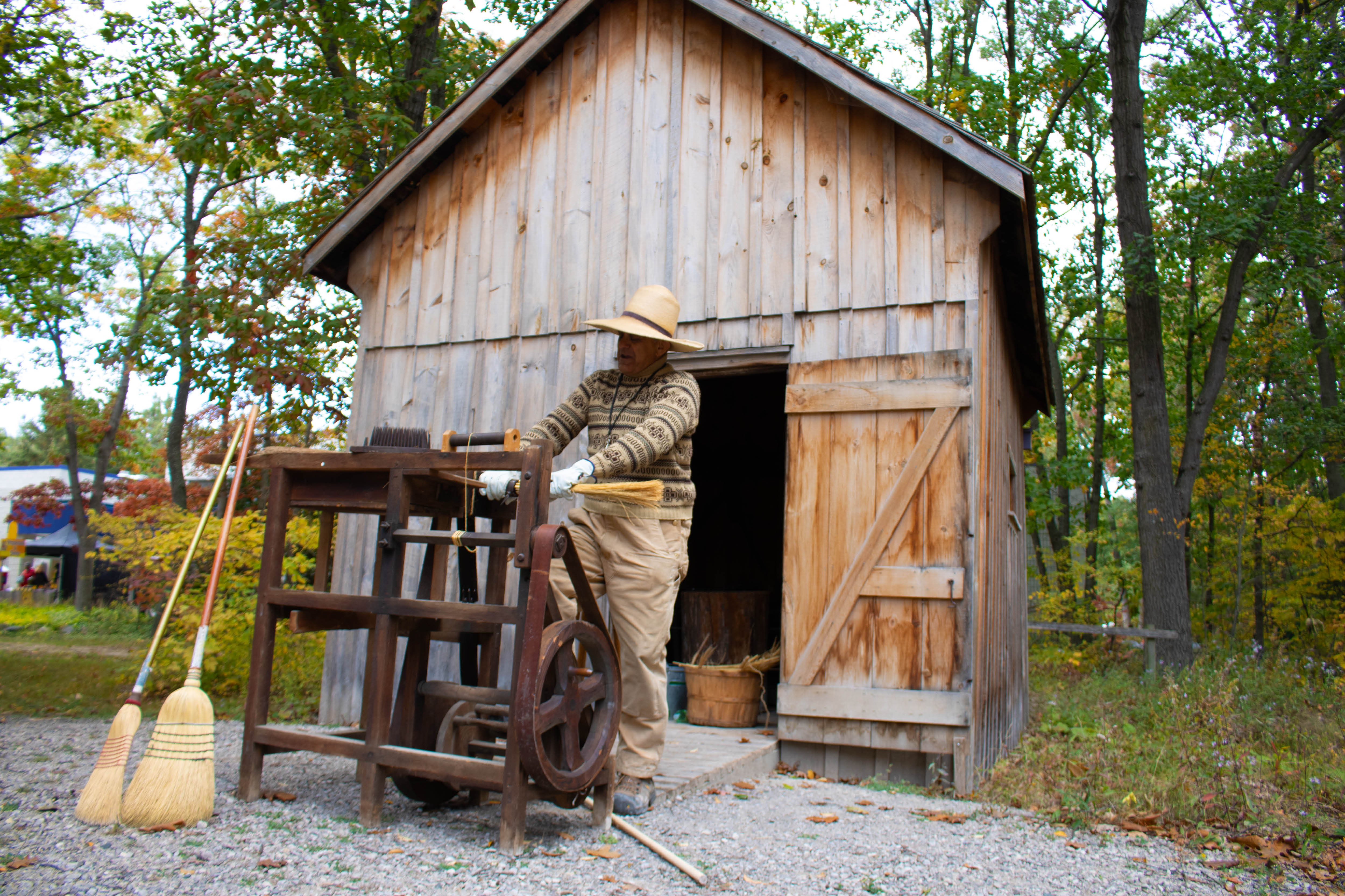 Lambton Heritage Museum staff member demonstrates how to make a corn broom outside one of the museum's historical buildings.