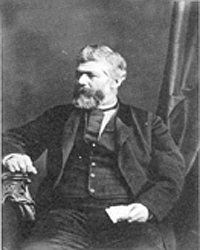 Black and white image of a man sitting in a chair.