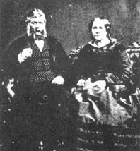 Black and white image of a man and women sitting in chairs.